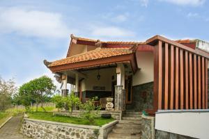 una casa con techo y porche en Shanty's House, en Batu