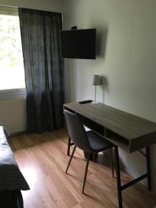 a desk with a chair in a room with a window at Hotel Yöpuu in Kemi