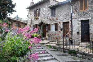 an old stone house with flowers in front of it at Da Marzietta in Assisi