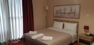 a bedroom with a bed with two towels on it at Hotel Vasilis in Nafplio