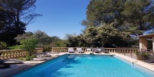 a swimming pool with chairs and a fence at Le Domaine d'Alèzen in Grans