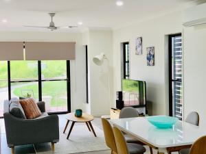 a living room with a white table and chairs at AIRLIE BEACH Delight. Hop, skip jump to everything in Cannonvale