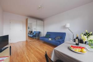 ワルシャワにあるP&O Apartments Namyslowskaのリビングルーム(テーブル、青いソファ付)