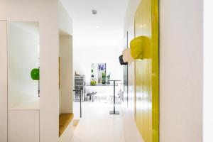 Habitación con un pasillo con paredes blancas y detalles en amarillo. en Le Funi Hotel, en Bérgamo