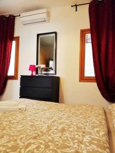 a bedroom with a bed with red curtains and a mirror at 458 Giardini in Venice +12 photos