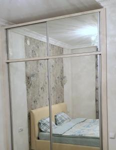1 dormitorio con armario de cristal y cama. en Batusi Apartment, en Batumi