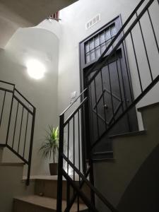 a hallway with stairs and a door with a potted plant at Ai Mori in Palermo