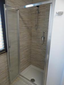 una doccia con porta in vetro in bagno di W LE VACANZE a Rimini