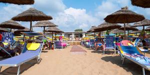 un mucchio di sedie e ombrelloni su una spiaggia di Hotel Pompeo Residence a Castellabate