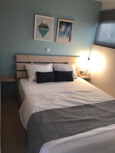 a bedroom with a large white bed and a lamp at ORFEAS SUITE in Nea Peramos