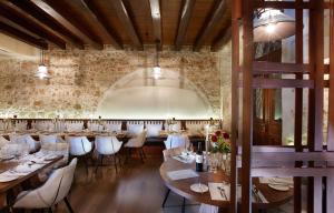 a restaurant with tables and white chairs and a brick wall at Serenissima Boutique Hotel in Chania Town