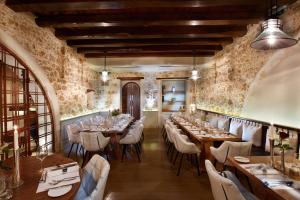 un restaurante con mesas largas y sillas blancas en Serenissima Boutique Hotel, en La Canea