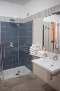 ein Badezimmer mit einer Dusche, einem Waschbecken und einer Badewanne in der Unterkunft Hotel Apeneste in Mattinata