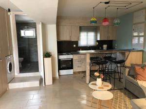a kitchen and living room with a couch and a table at ORFEAS SUITE in Nea Peramos