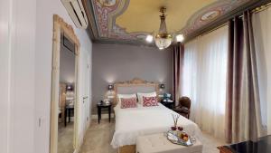 a bedroom with a white bed and a chandelier at Faik Pasha Hotels Special Category Beyoglu Istanbul in Istanbul