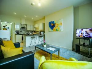 a living room with a couch and a table and a kitchen at Spacesavers at Figtree Lane in Sheffield