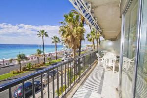 d'un balcon avec vue sur l'océan et les palmiers. dans l'établissement PROMENADE HOLIDAY - CARIATIDE PROMENADE SEA VIEW, à Nice