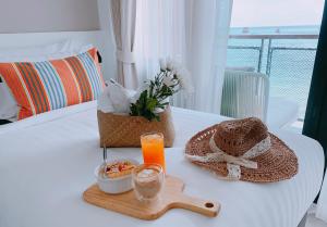 a table with a tray of food and a glass of orange juice at Blue Tao Beach Hotel - SHA Plus in Koh Tao