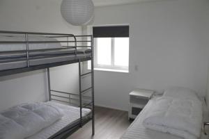 two bunk beds in a room with a window at Private Spacious Home in City Center in Klaksvík