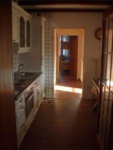 una cucina con lavandino e una porta per un corridoio di Pension-Stürrad a Neuharlingersiel