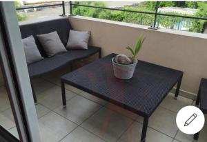 d'un balcon avec une table, une chaise et une plante. dans l'établissement Studio Bis Cocoon, à Saint-Gilles les Bains