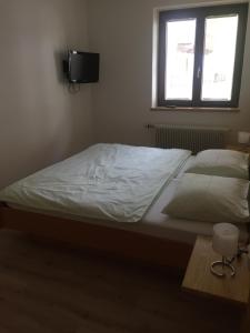 a bedroom with a bed and a tv on the wall at Appartement Central in Bruck an der Großglocknerstraße