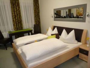 a bedroom with two beds and a mirror on the wall at Cafe und Pension Ringer in Vilseck