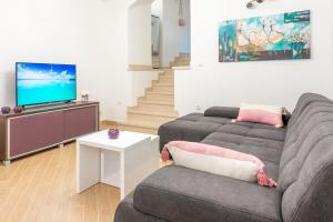 a living room with two couches and a flat screen tv at Apartment Laura in Dubrovnik