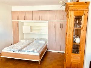 Bett in einem Zimmer mit Holzschränken in der Unterkunft Wurmberg Baude 1 in Braunlage