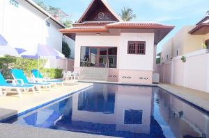 a villa with a swimming pool and a house at Majestic Villas Phuket in Rawai Beach