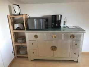 a dresser with a microwave on top of it at Gästehaus Grabbe in Prien am Chiemsee