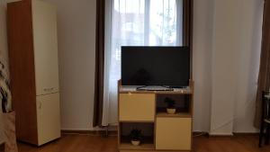 sala de estar con TV en un soporte en Lend one room house, en Miercurea-Ciuc