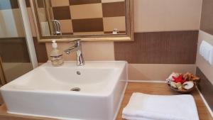 uma casa de banho com um lavatório branco e um espelho. em Lend one room house em Miercurea Ciuc