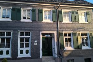 un edificio con ventanas verdes y blancas y una puerta en FEWO Hückeswagen "Das Historische", en Hückeswagen
