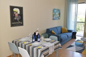 a living room with a table and a blue couch at Casa Dollu in Rivarolo Canavese