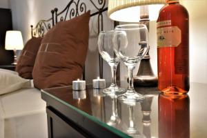 una bottiglia di vino e due bicchieri di vino su un tavolo di Ostria Studios ad Adámas