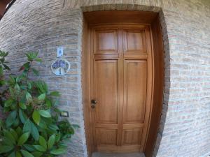 uma porta de madeira num edifício de tijolos com uma planta em Casa Gardenia em Toscolano Maderno