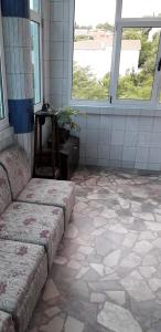 a room with a couch and a tiled floor with windows at Hostel -Sema-House in Mostar