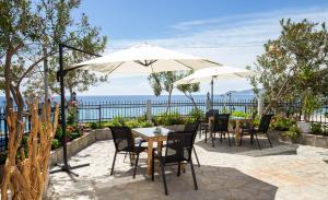 un patio avec tables, chaises et un parasol dans l'établissement Pension Ageri, à Potos