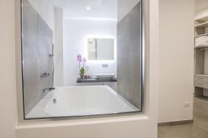 biała łazienka z wanną i umywalką w obiekcie SuitesGaribaldi w Cagliari