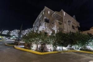 a building with trees in front of it at night at Seven Gardens Pro in Al Hada