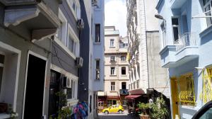a narrow alley with a yellow car on a street at Windrose Hostel Istanbul in Istanbul