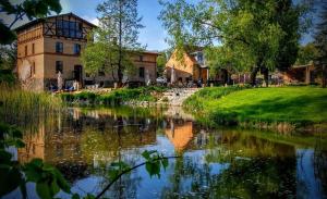ein Gebäude neben einem Fluss neben einem Gebäude in der Unterkunft Mühle Tornow am Wentowsee in Tornow