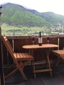 a bottle of wine sitting on a table with two glasses at Apartment Jorjo Mestia in Mestia