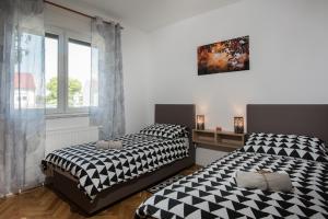 two beds sitting next to each other in a bedroom at Seasons apartmani in Osijek