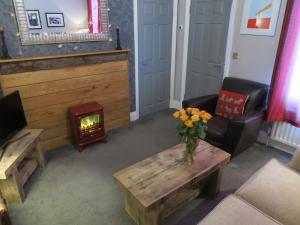 - un salon avec un vase de fleurs sur une table dans l'établissement Parkside Apartments, à Newcastle upon Tyne