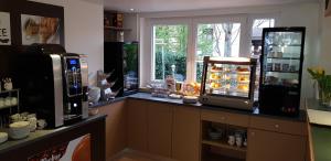 a kitchen with a counter with a refrigerator and a window at H41 Inn Hotel Garni Freiburg in Freiburg im Breisgau
