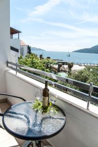 a table with wine glasses and a view of the ocean at Apartments Mako in Herceg-Novi