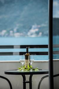 a table with two glasses and a bottle on it at Apartments Mako in Herceg-Novi