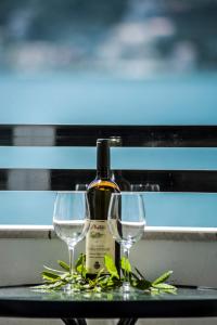 a bottle of wine and two glasses on a table at Apartments Mako in Herceg-Novi